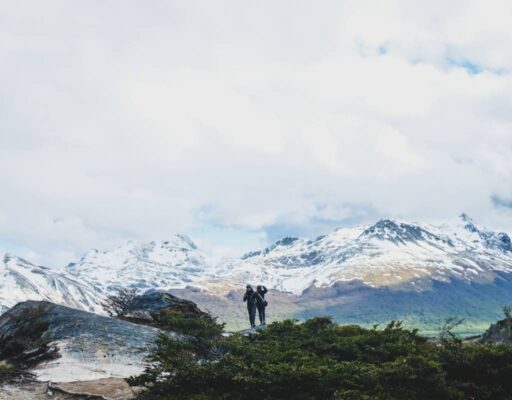 Dos senderistas caminando hacia montañas nevadas durante un trekking en Ushuaia