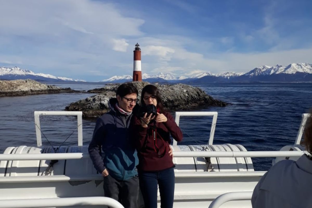 Faro les Eclaireurs desde el catamaran con personas tomando foto