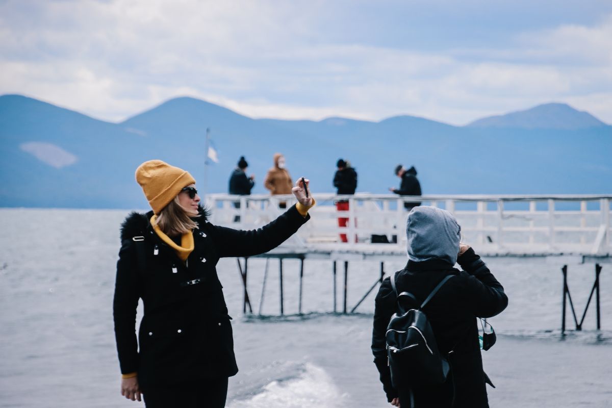 personas tomando una foto en el Lago Fagnano con el muelle