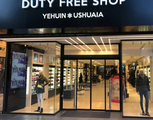 Frente de Yehuin Duty Free Shop Ushuaia con cartel negro y vidriera iluminada